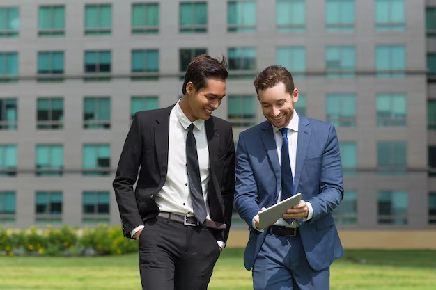 two-smiling-business-men-using-tablet-walking_1262-3336